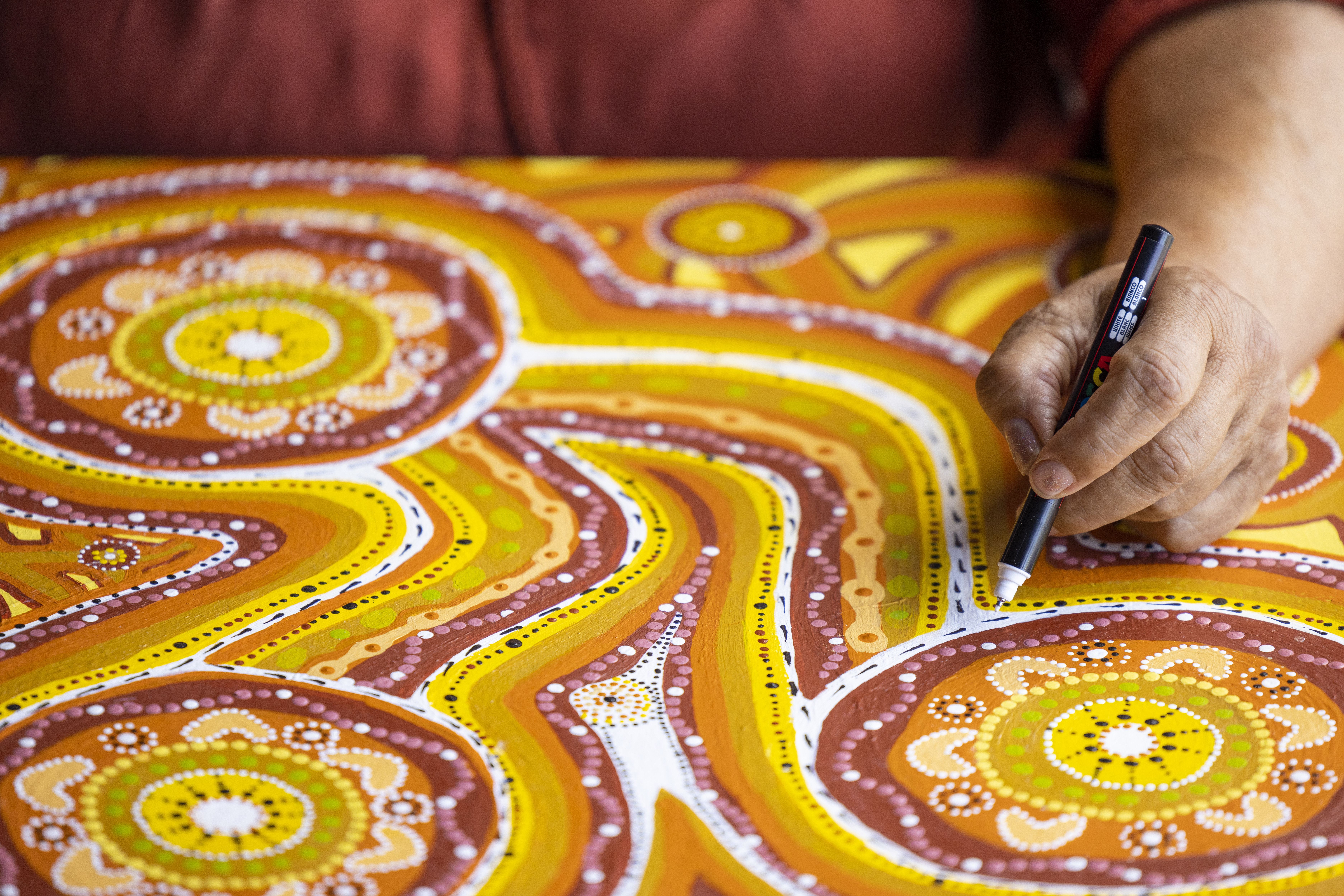 Close up of a person's hand adding detail to an artwork