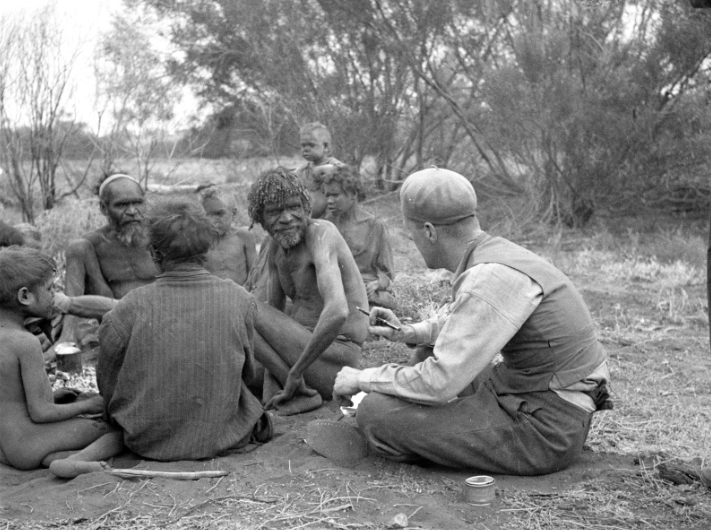 A history black and white photo of people sitting down in a group