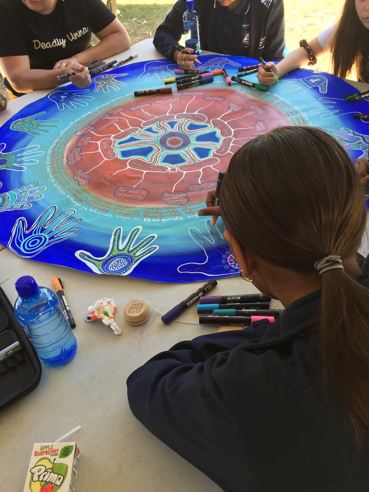Artists working on an Aboriginal artwork
