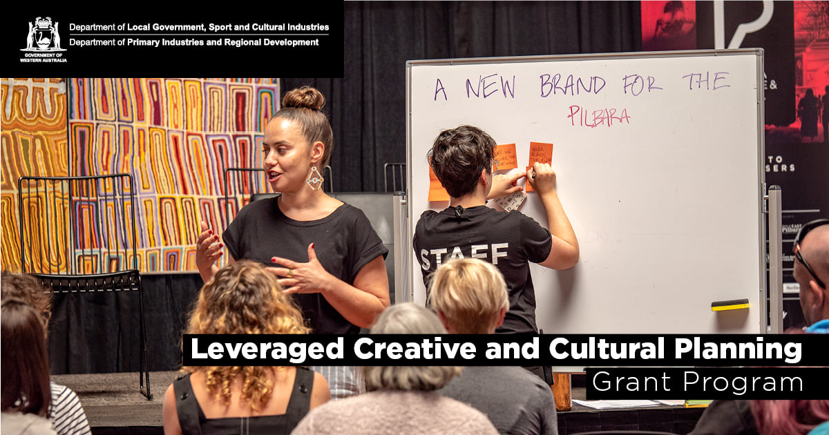 Leveraged Creative and Cultural Planning Grant Program. A facilitator talking to an audience with someone writing on post-it notes on a white board.