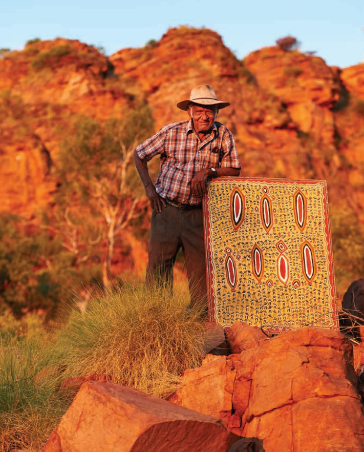 Alan Griffiths standing next to one of his paintings