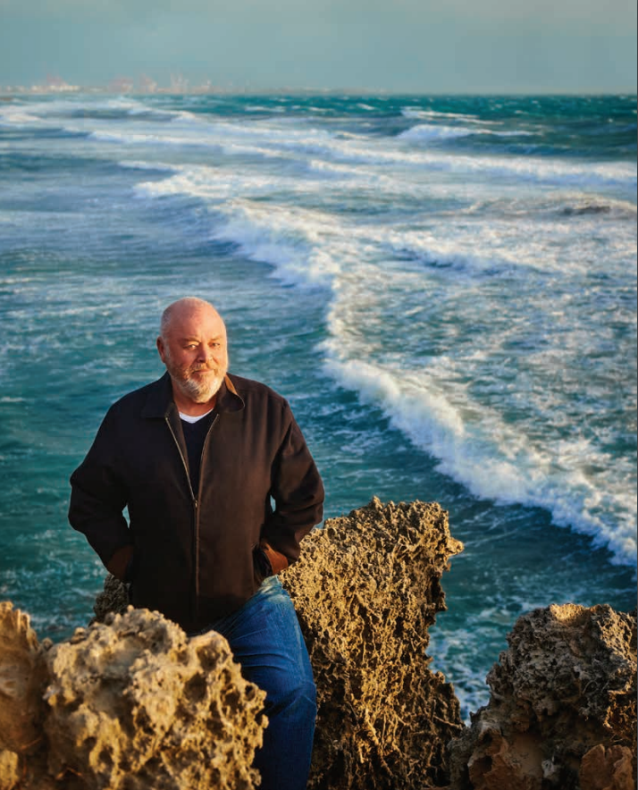 Robert Drewe sitting on a rock