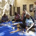 Revealed 2017 Market. Photo by Jessica Wyld. Aboriginal ladies sculpting wood sitting on the ground at Fremantle Arts Centre.