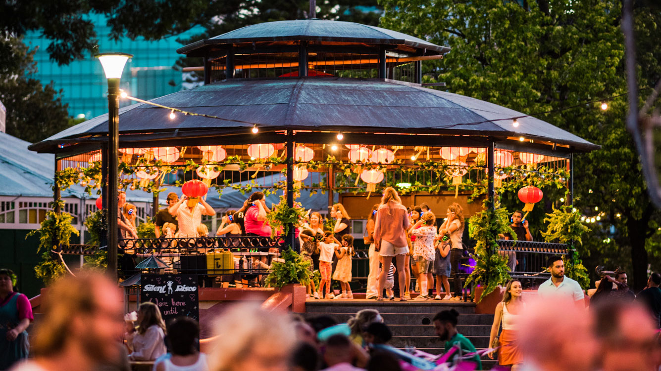 Audience at the Silent Disco in the Pleasure Garden lit up with lights