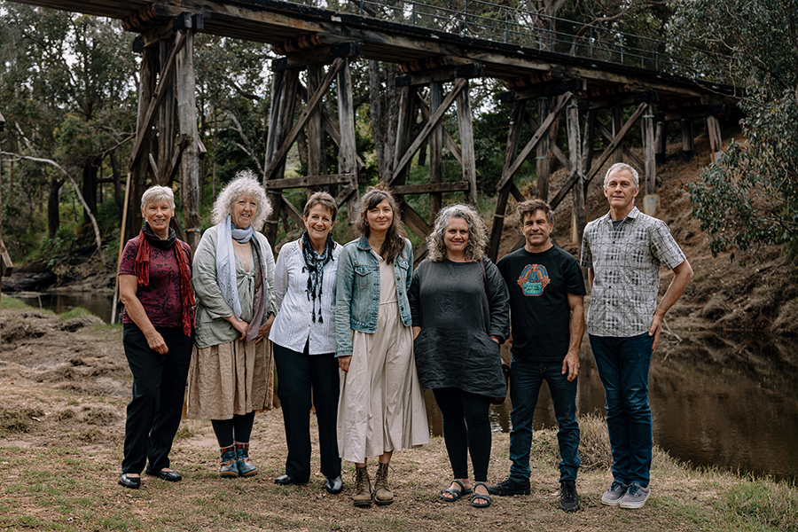 Nannup Music Festival Staff smiling at the camera close to a wooden bridge in the bush. 