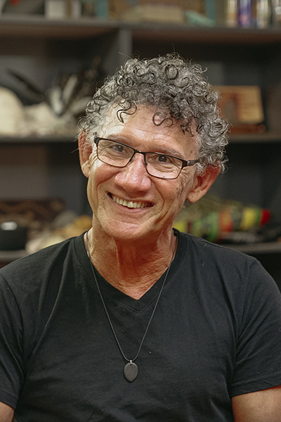 A smiling man wearing glasses looking at an interviewer 