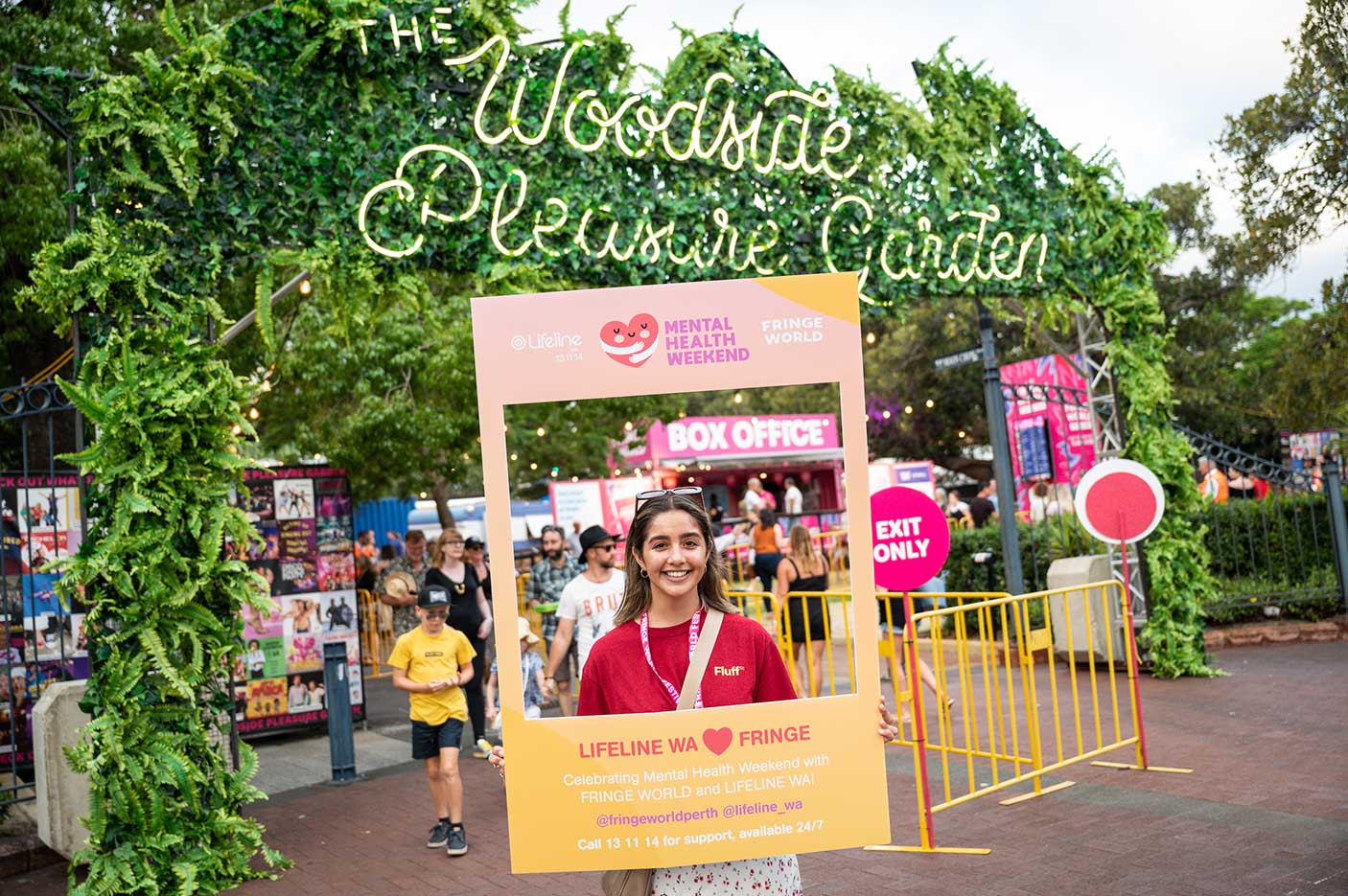 A woman holding a social media frame in front of the Woodside Pleasure Garden