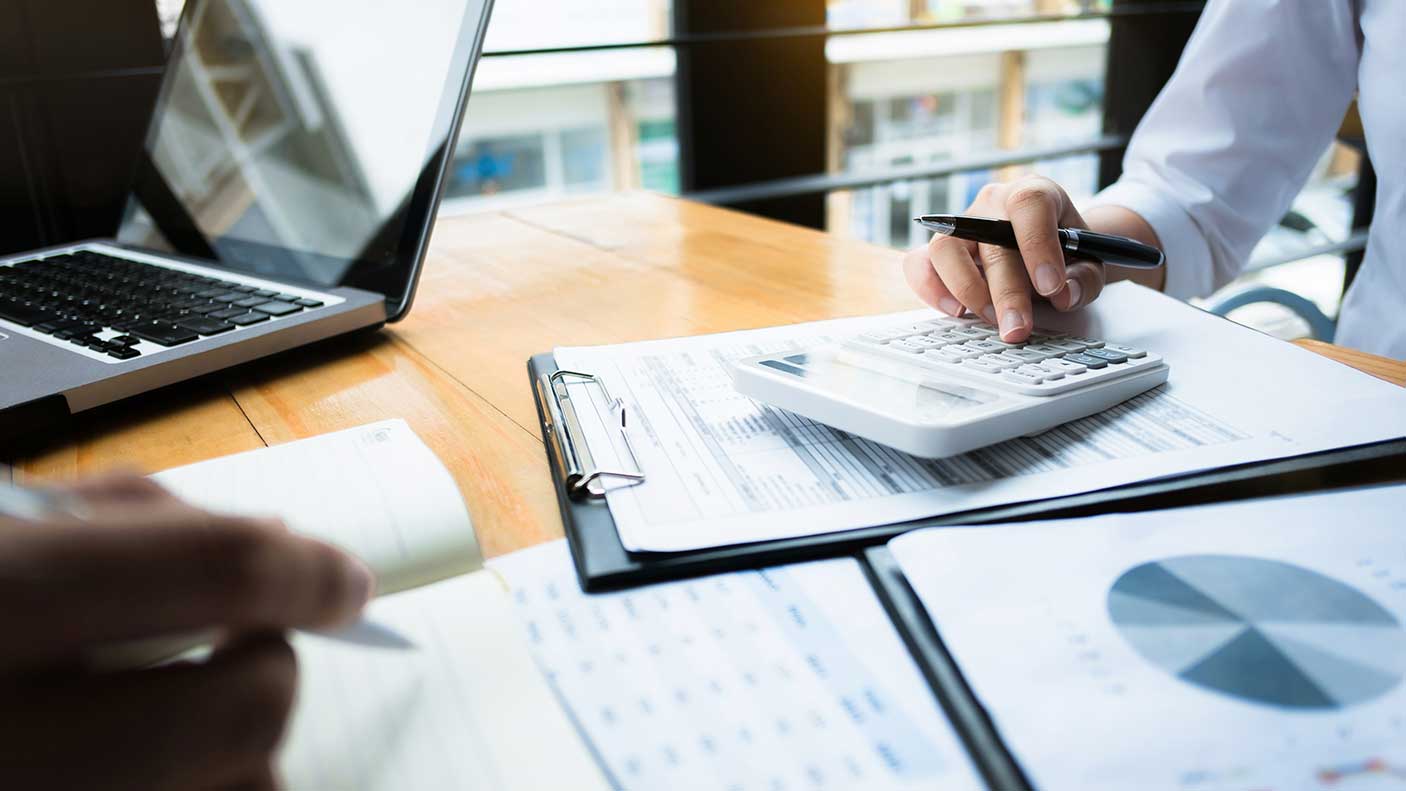 A close up of who people budgeting using a computer and calculator