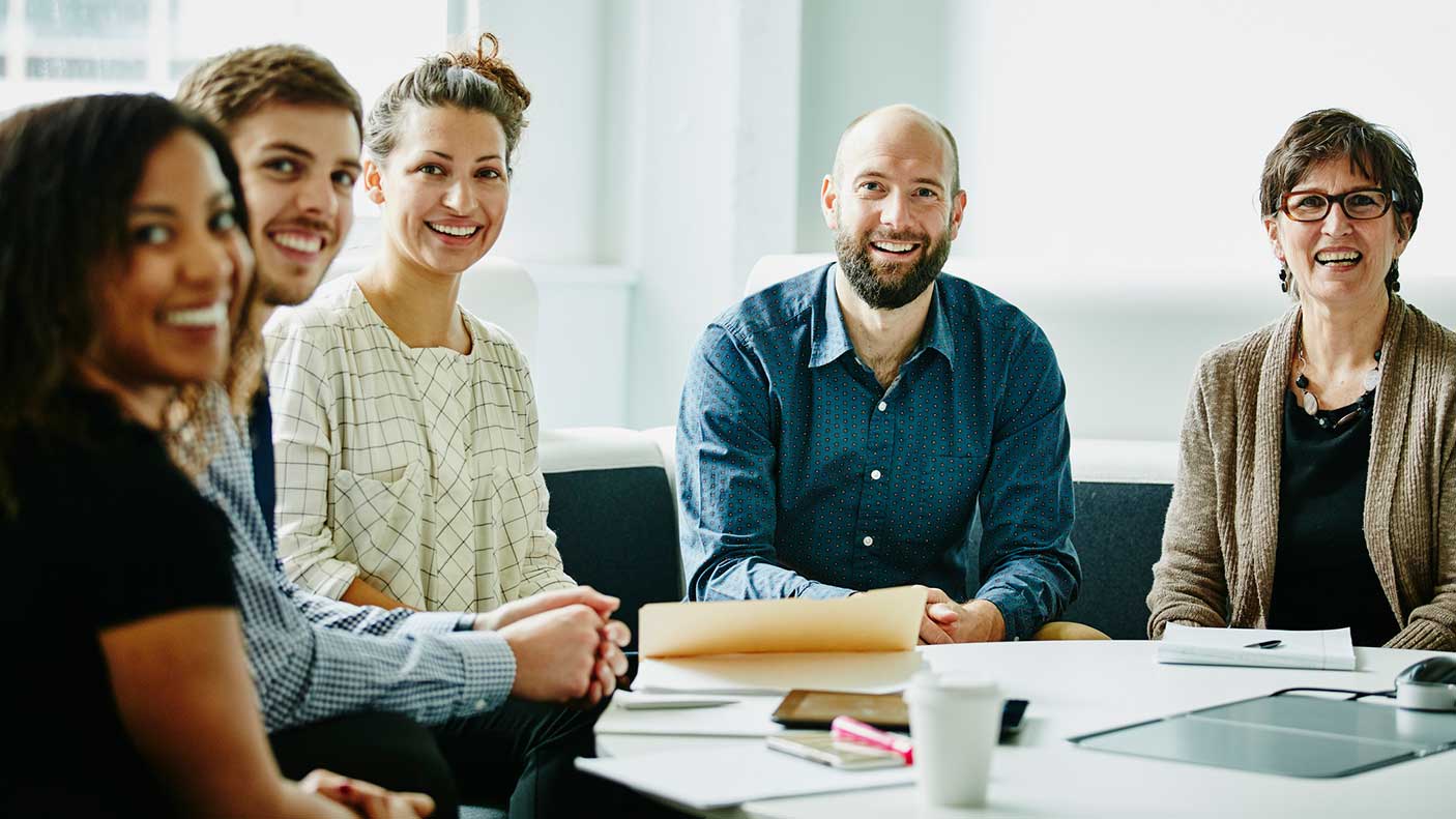 Smiling group of businesspeople in team meeting in office conference room