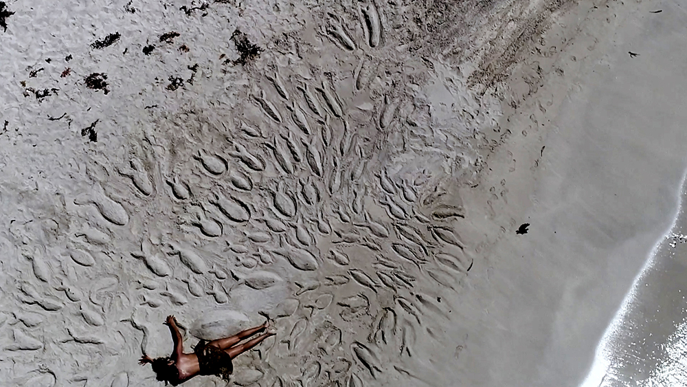 Man laying on a beach.