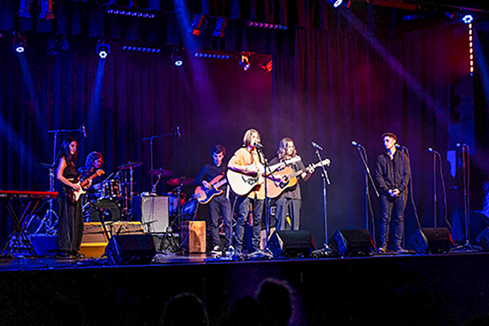 A group of young musicians performing on stage.