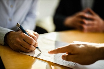A person signing a piece of paper