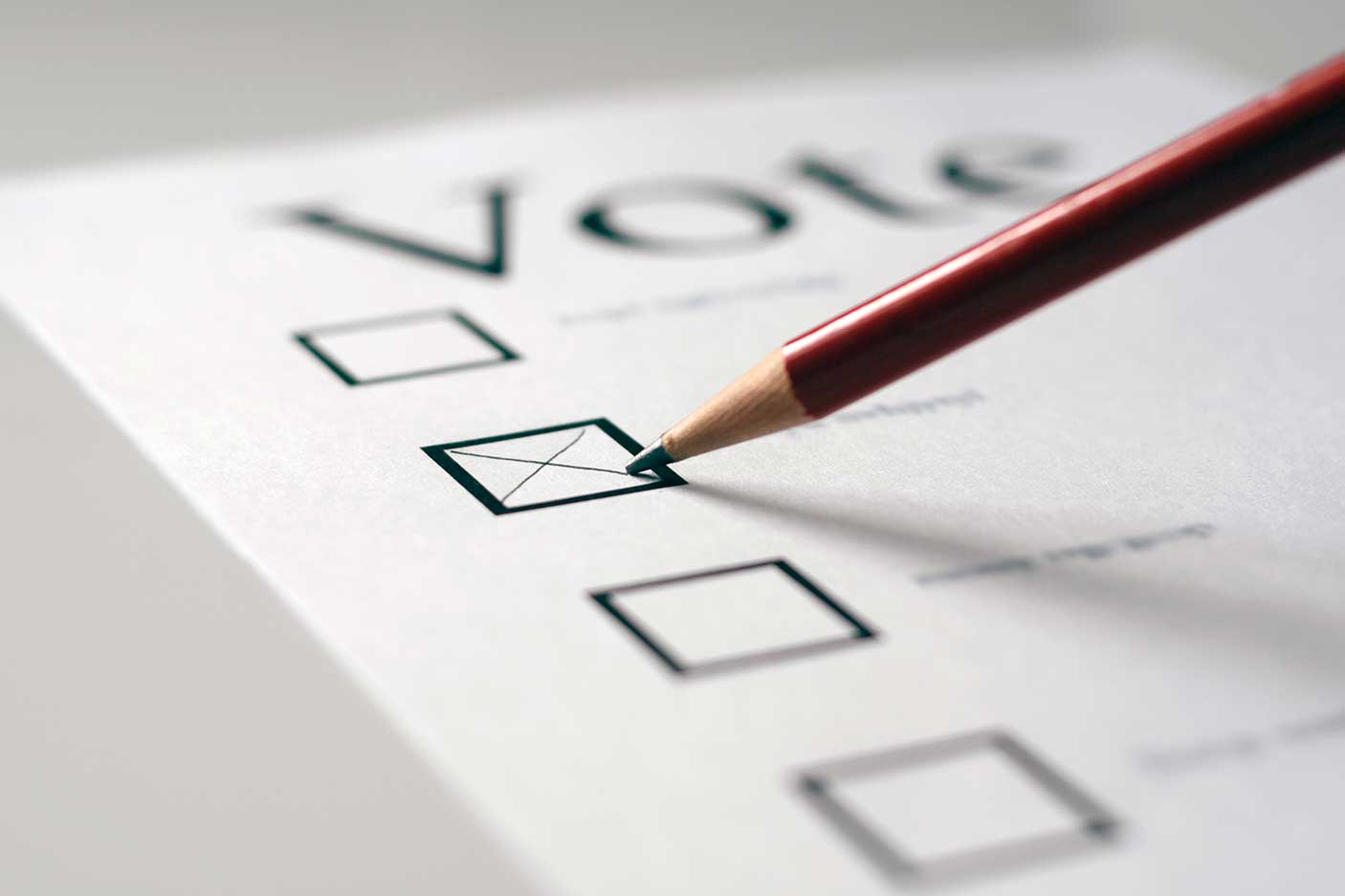 This is a voting card marked with an x in the second box with a pencil. The focus is on the pencil tip.
