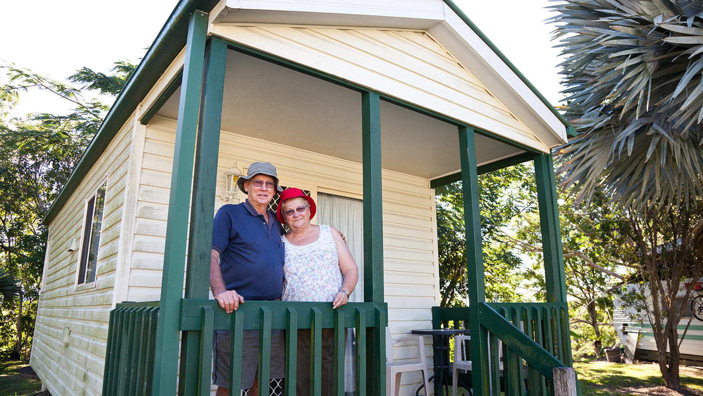 An elderly couple standing in front of their park home