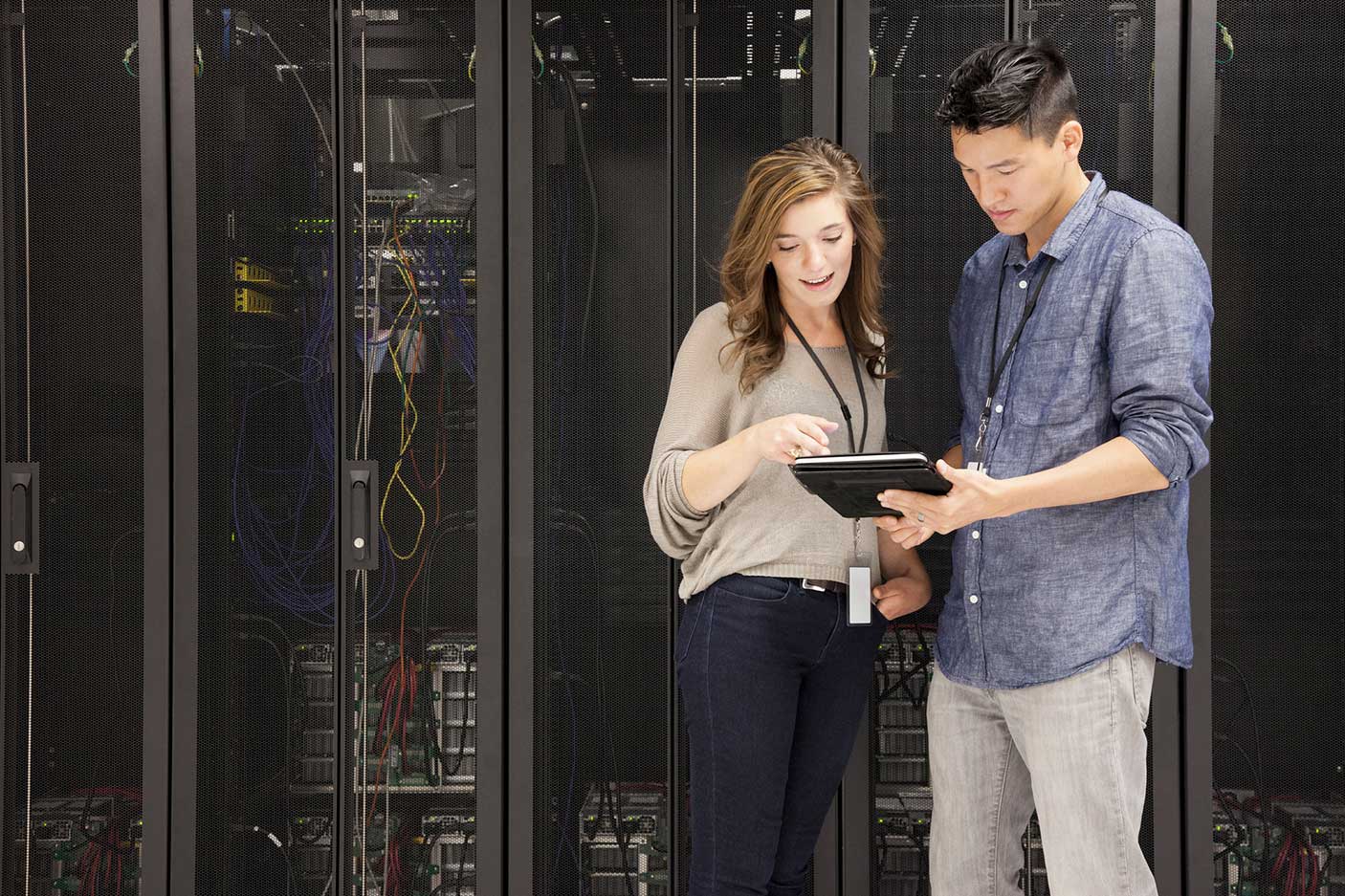 Business people using tablet computer in server room