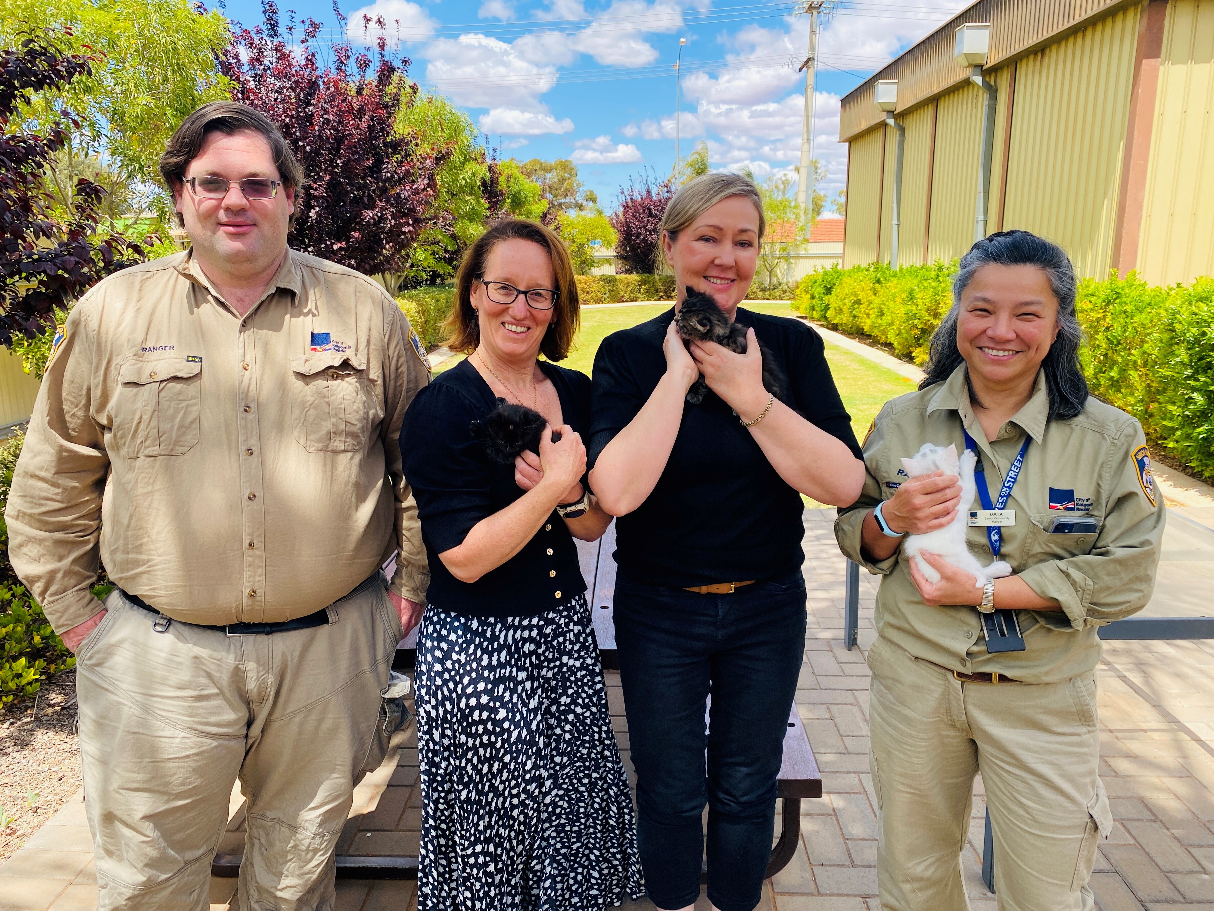 Four people holding cats