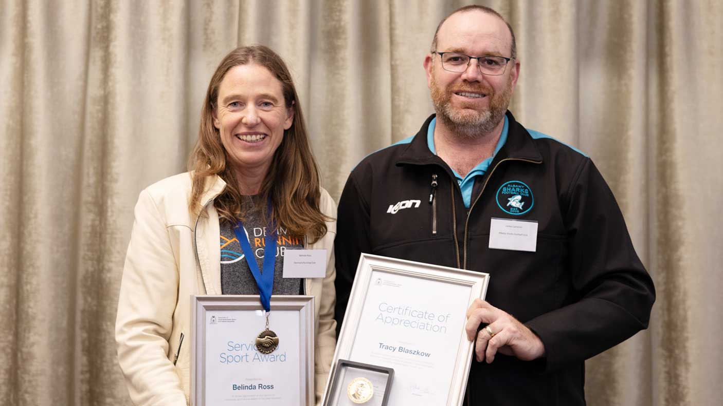 A man and a woman holding framed certificates