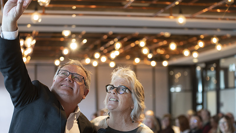 Arts Minister David Templeman and a woman take a selfie in a crowded room