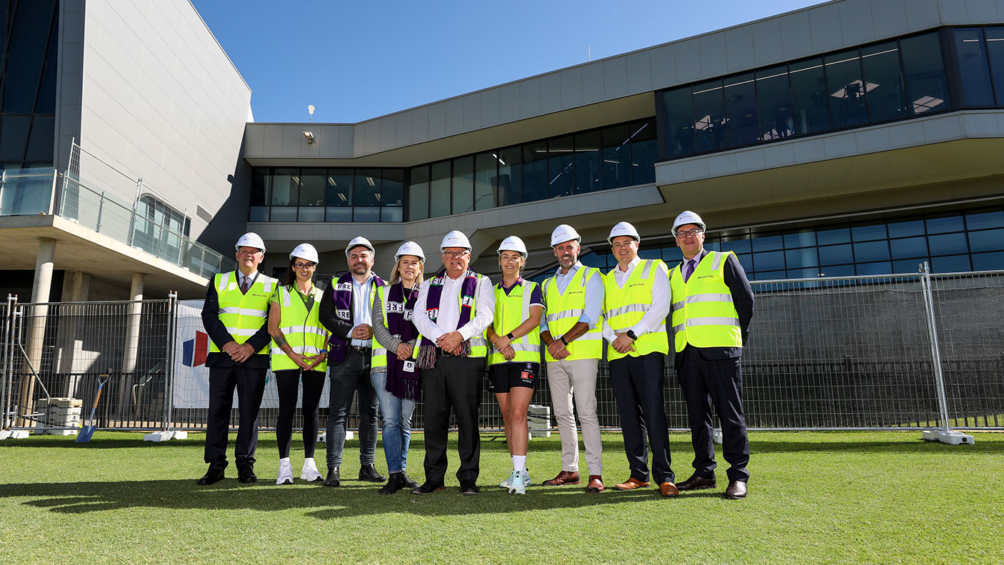 9 government officals in high-vis vests stand at the site of the new female and unisex changerooms at Cockburn ARC.