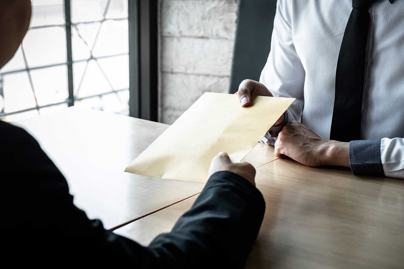 Business people with bribe at desk in office