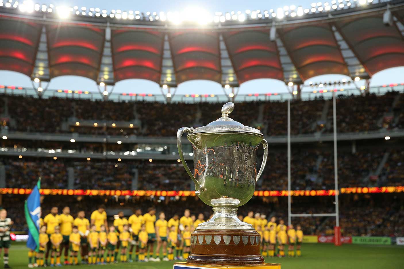 The Bledisloe Cup in focus with the Wallabies lined up behind it at Optus Stadium