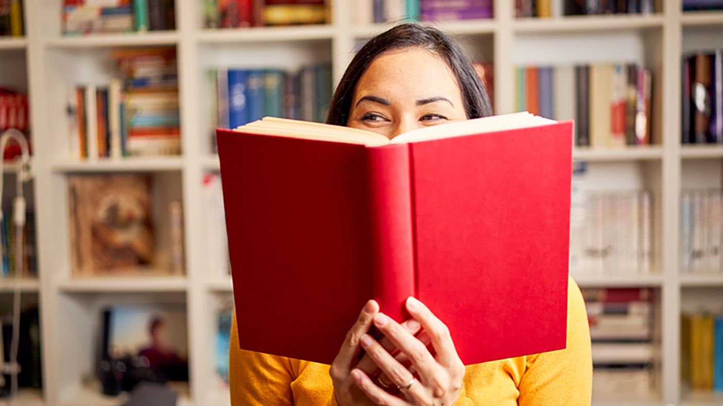 Woman reading a book in a library.