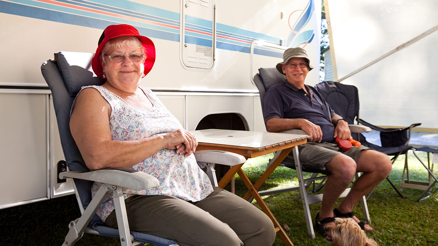 Two people sitting in front of their caravan