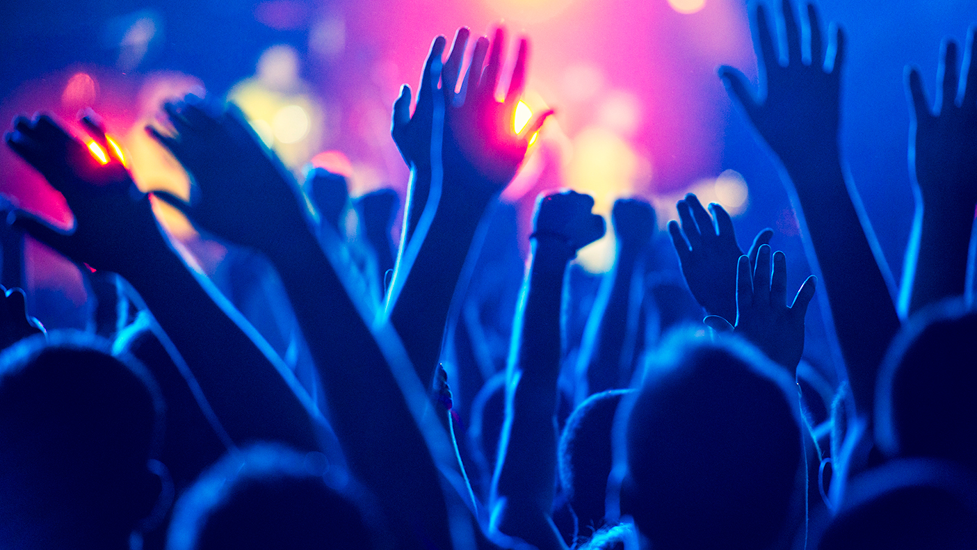 Close up of a crowd holding their hands up at a music event