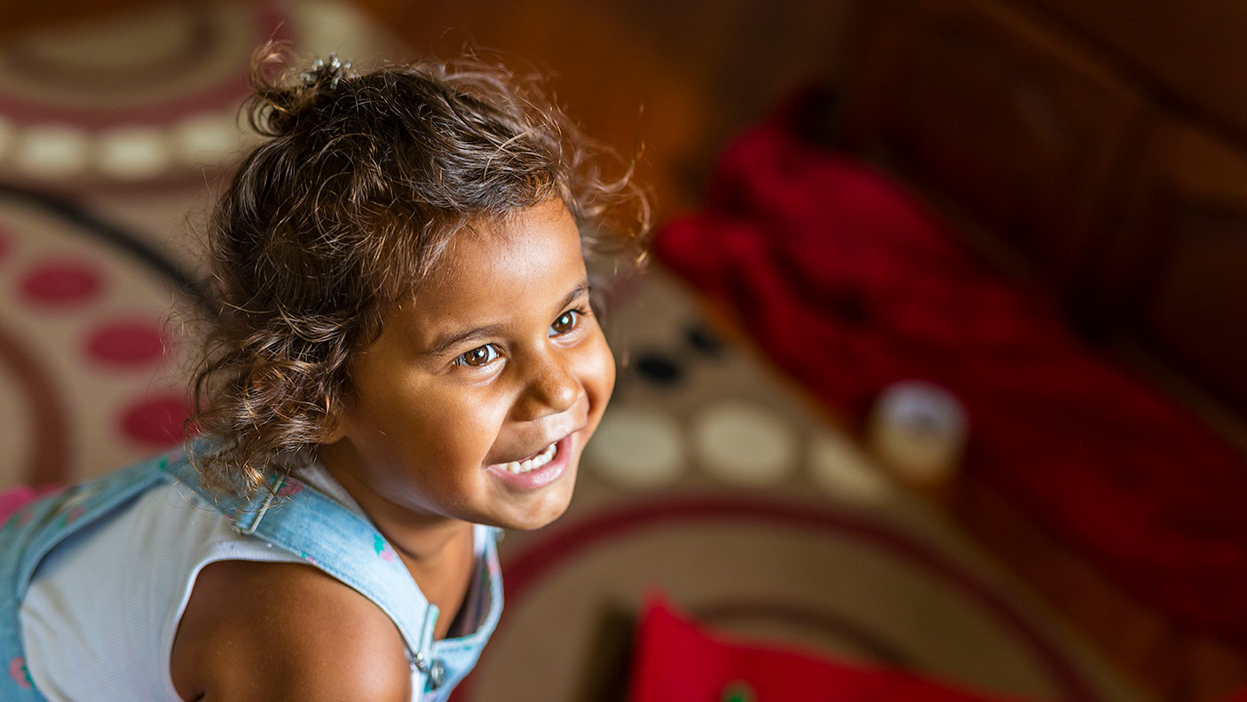 Happy Young Australian Aboriginal Girl Learning to Sing and Dance to a Song - stock photo