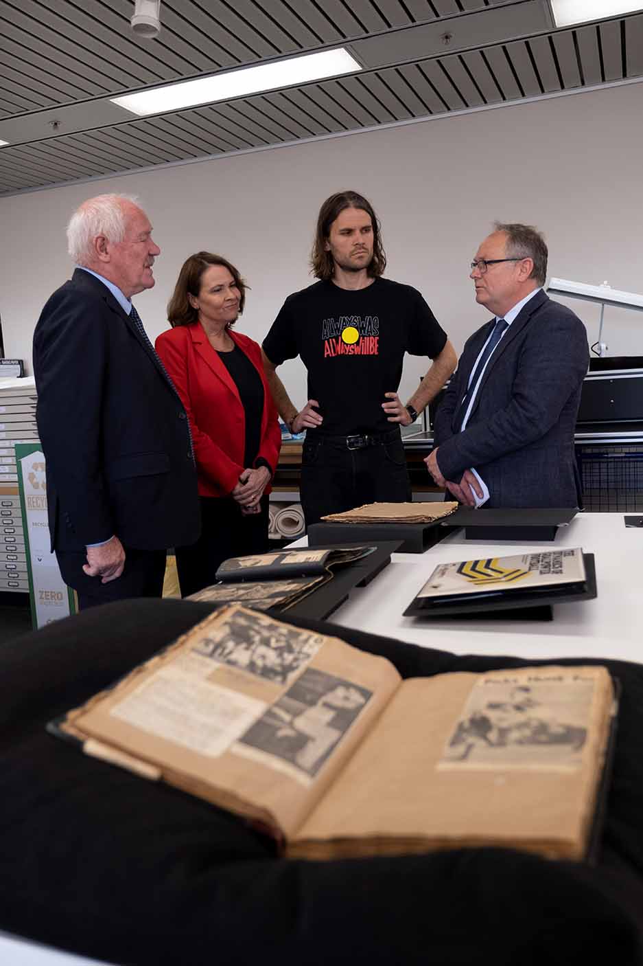 Graham Polly Farmer collection with Minister Murray, Minister Templeman and Farmer's daughter Kim and grandson Cole talking in front of items from the collection.