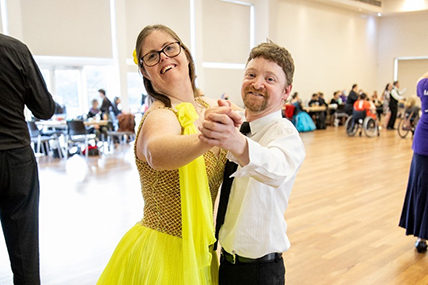 A lady and a gentleman dancing on a dance floor.