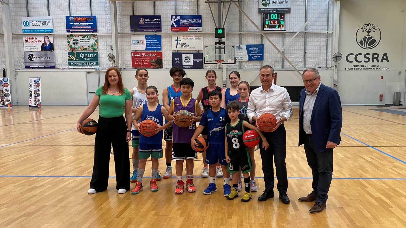 A group of junior basketball players with the Premier and Minister on a basketball court.
