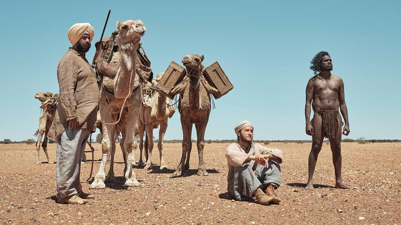 Still image from the film, The Furnace showing men and camels in a desert