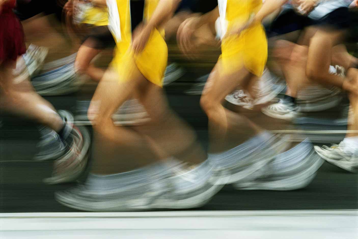 A close-up blurred image of marathon runners