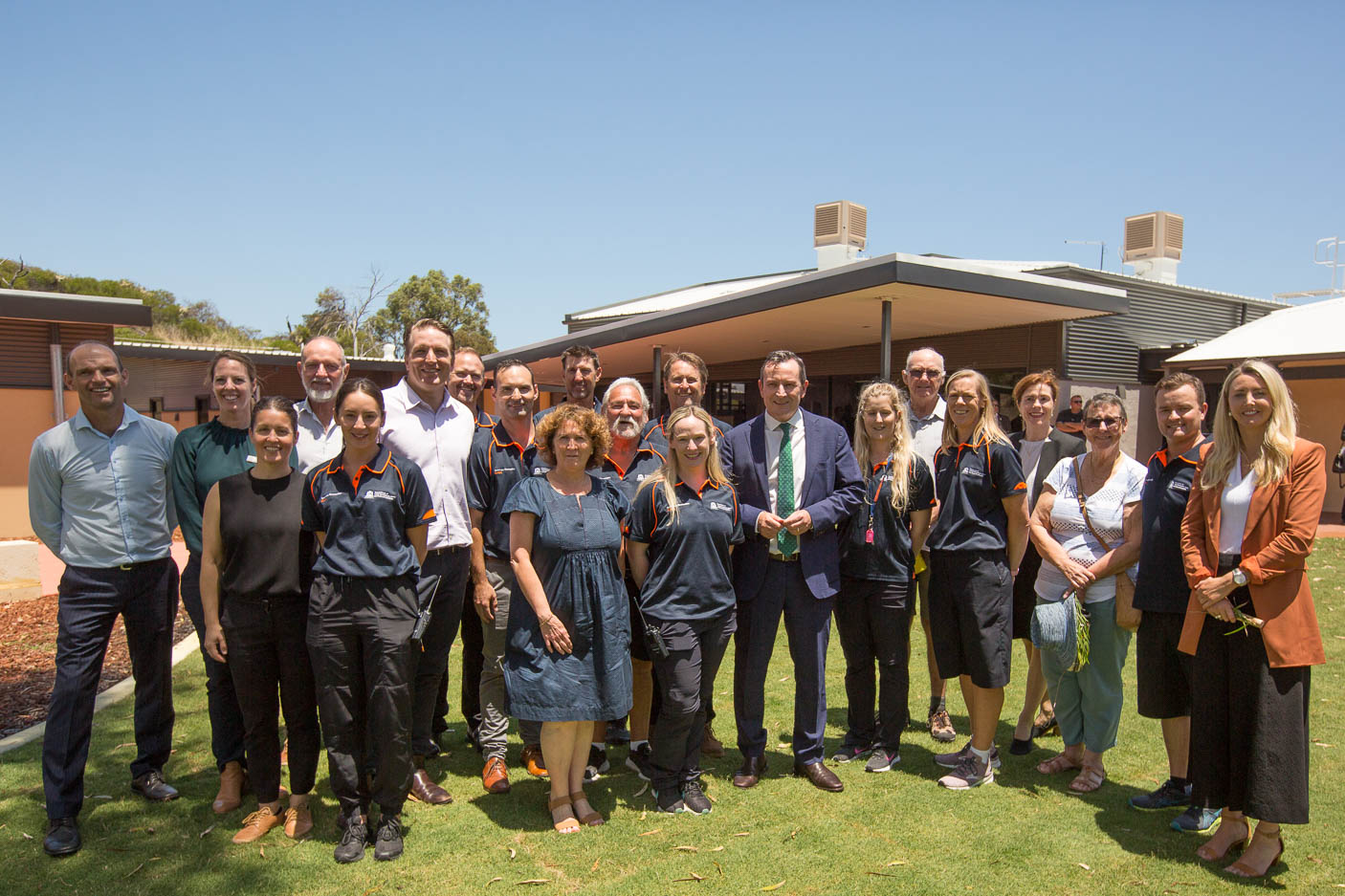 A group of people standing together in front of a newly opening dormitory