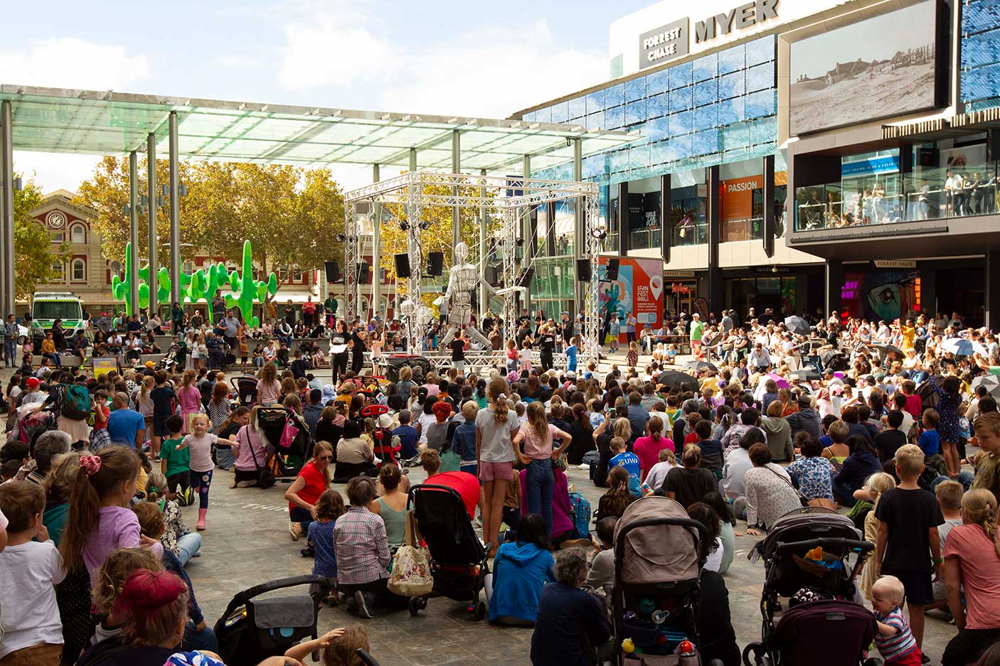 A crowd in Forrest Place watching a large puppet being moved.