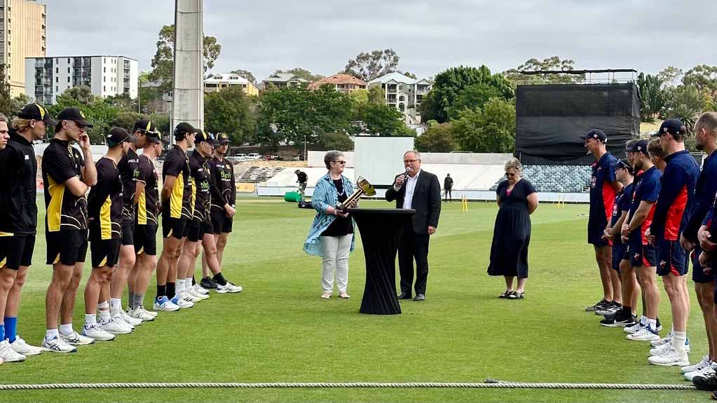 Minister David Templeman and Cricket WA CEO Christina Matthews talking in front WA and SA cricket teams