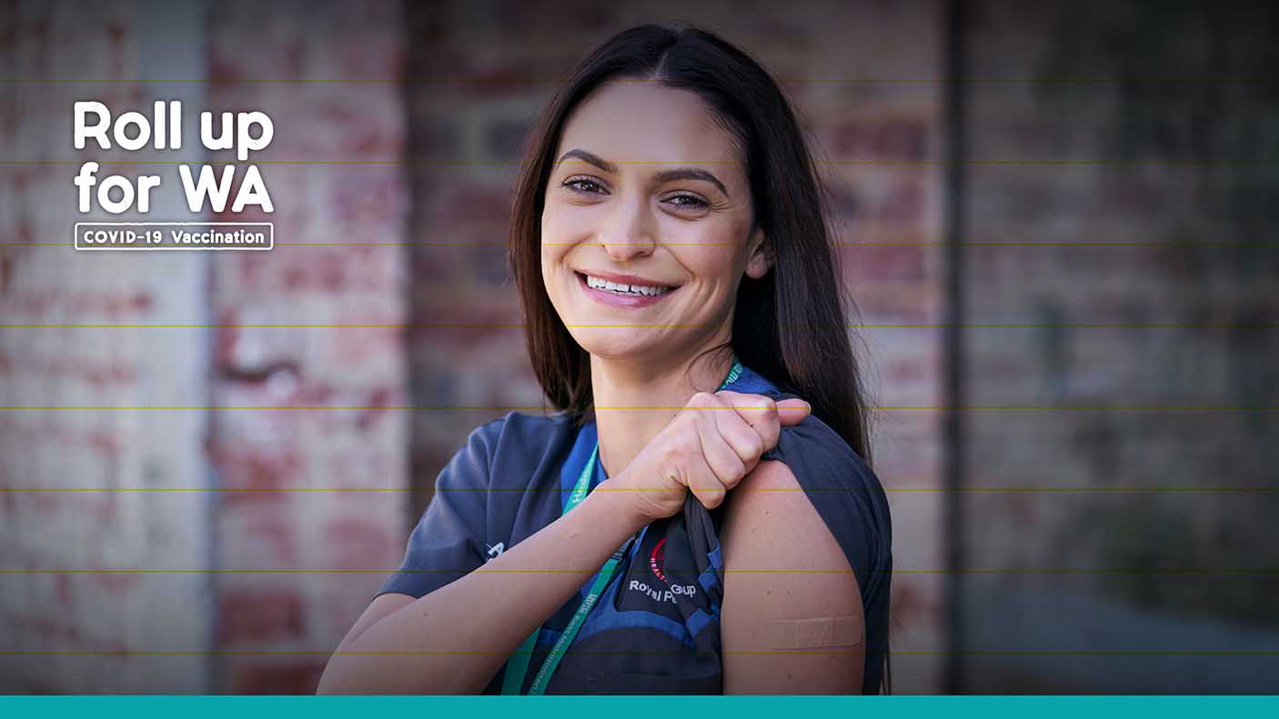 A nurse holding up her sleeve showing she has been vaccinated