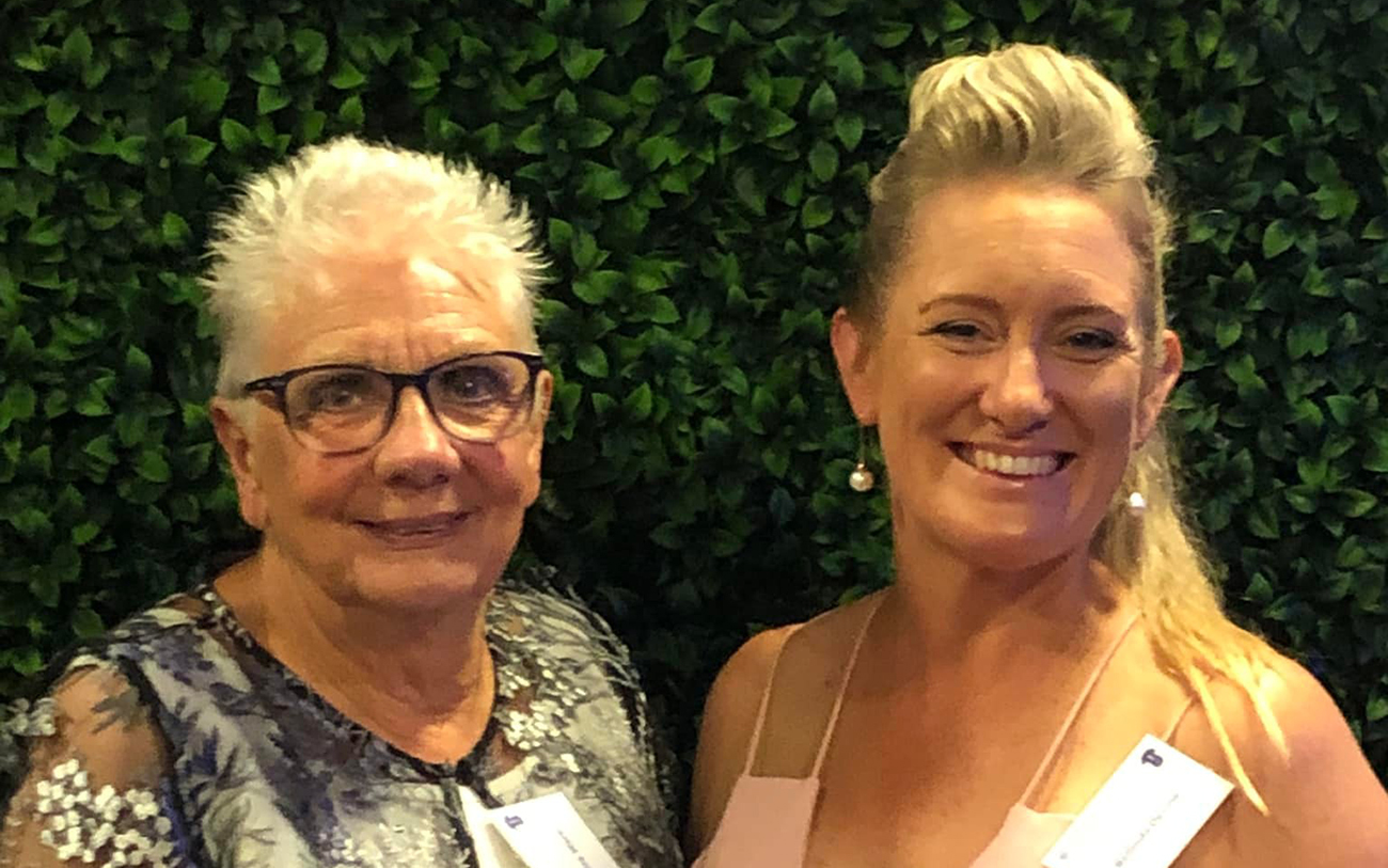 Two ladies smiling at the camera.