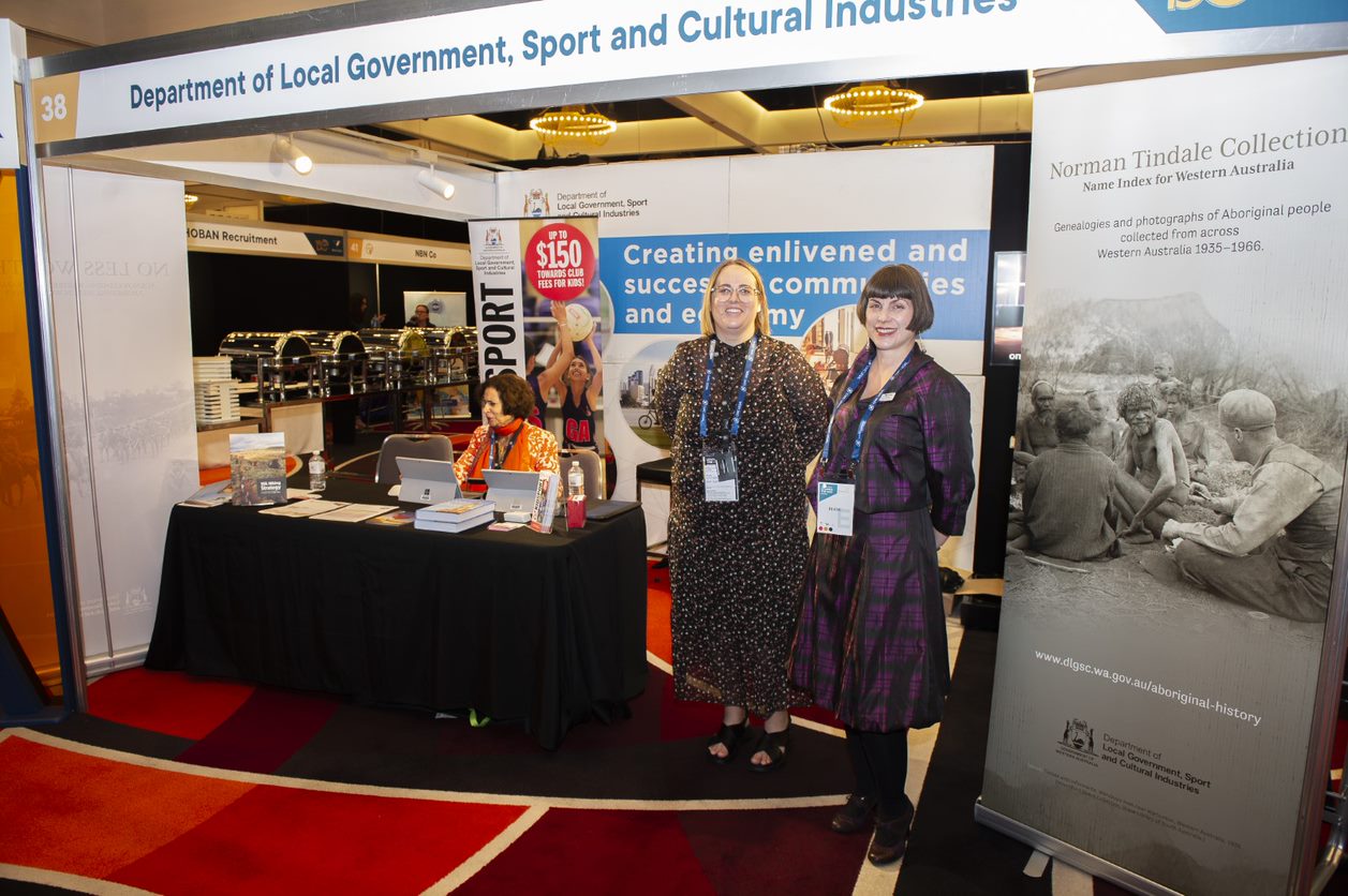 Staff at a conference stall with signage