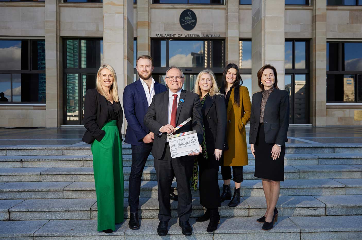 A group of 6 people standing on the steps in front of Parliament House.