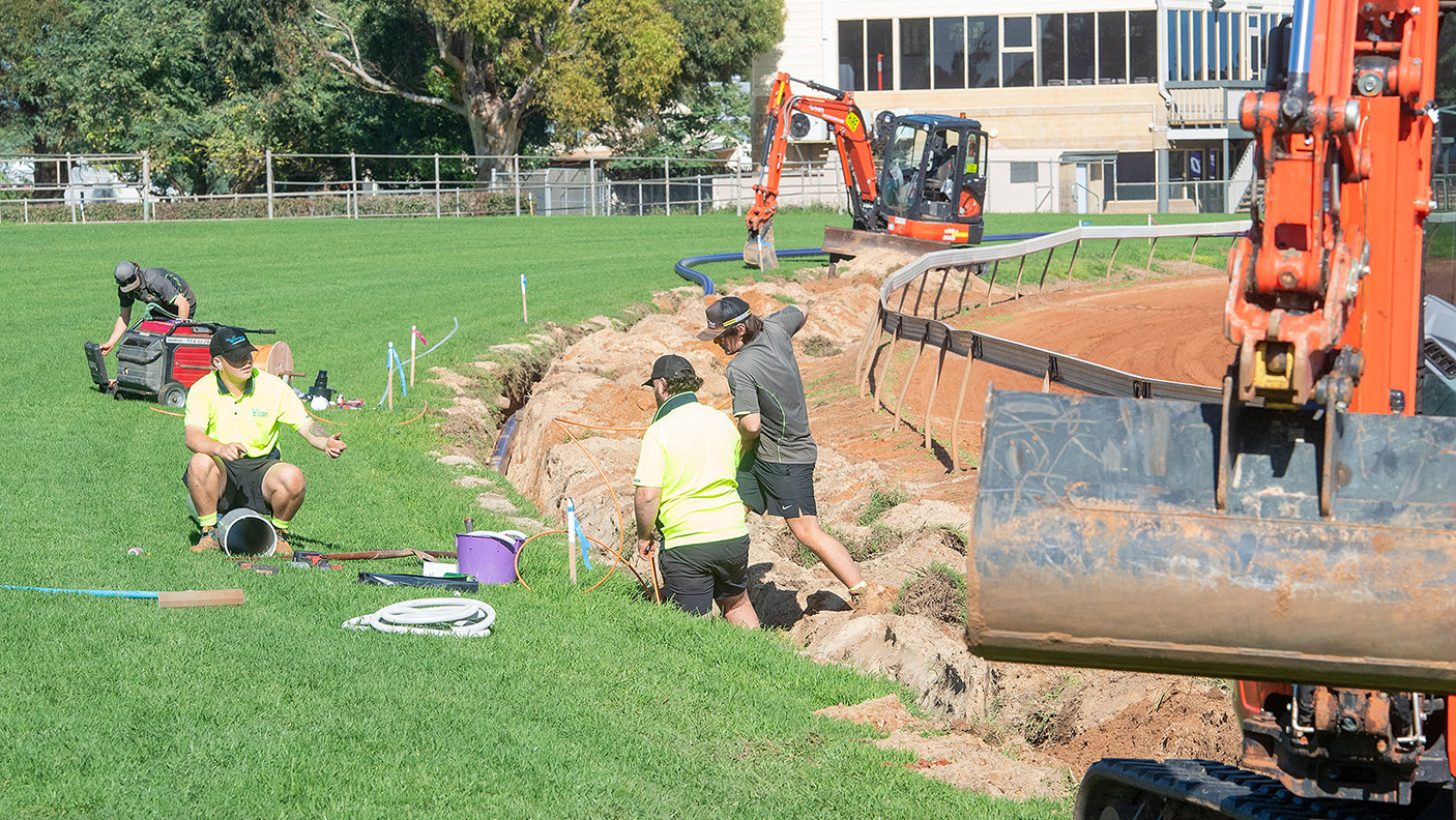 Workers in high vis working on the drainage works at Geraldton Turf Club