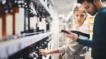 Couple buying some wine at a bottle shop.