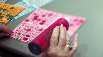 Closeup image of a bingo player marking off numbers
