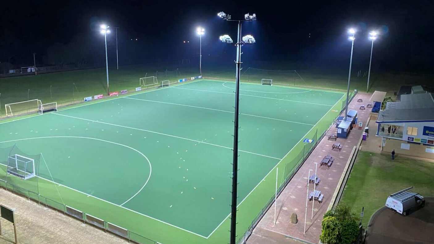 A hockey field a night illuminated by lights