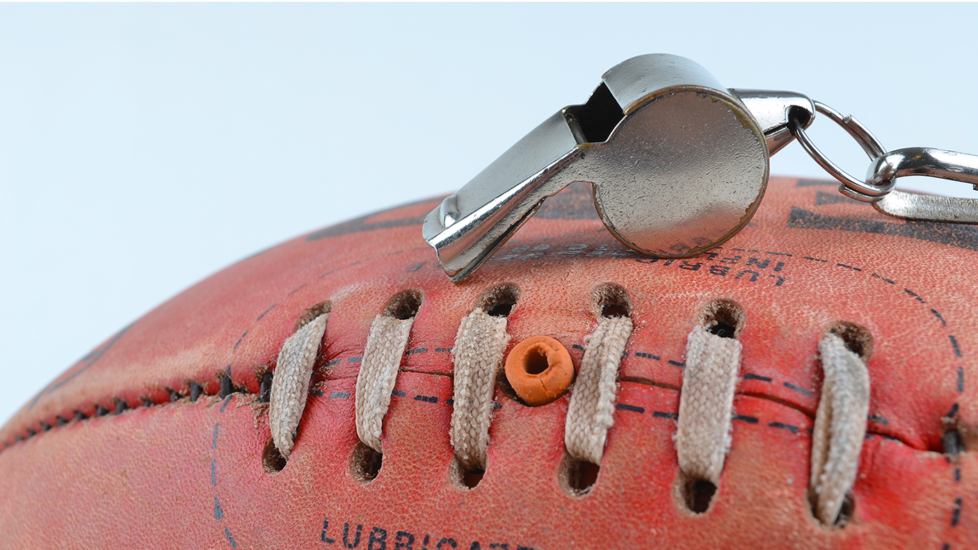 Close up of a red sports ball with an umpire's whistle
