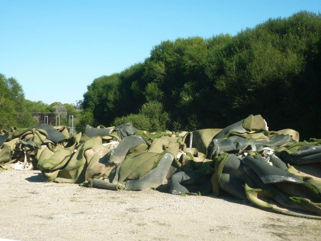 Disused sand filled synthetic turf waiting for transport to landfill