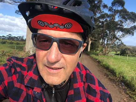 Portrait of Rod Annear wearing bike helmet on a riding trail