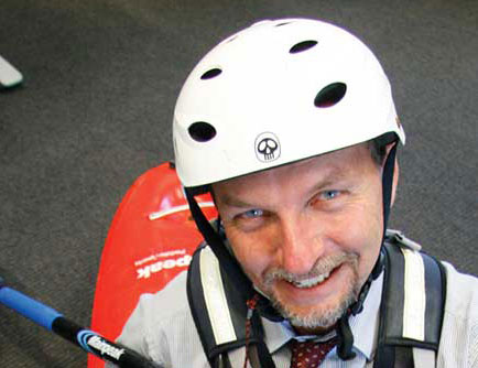 Portrait of Steve Bennet wearing a hard hat and rock climbing harness