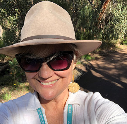 Portrait of Tabetha Beggs in hat and sunglasses on a trail walk